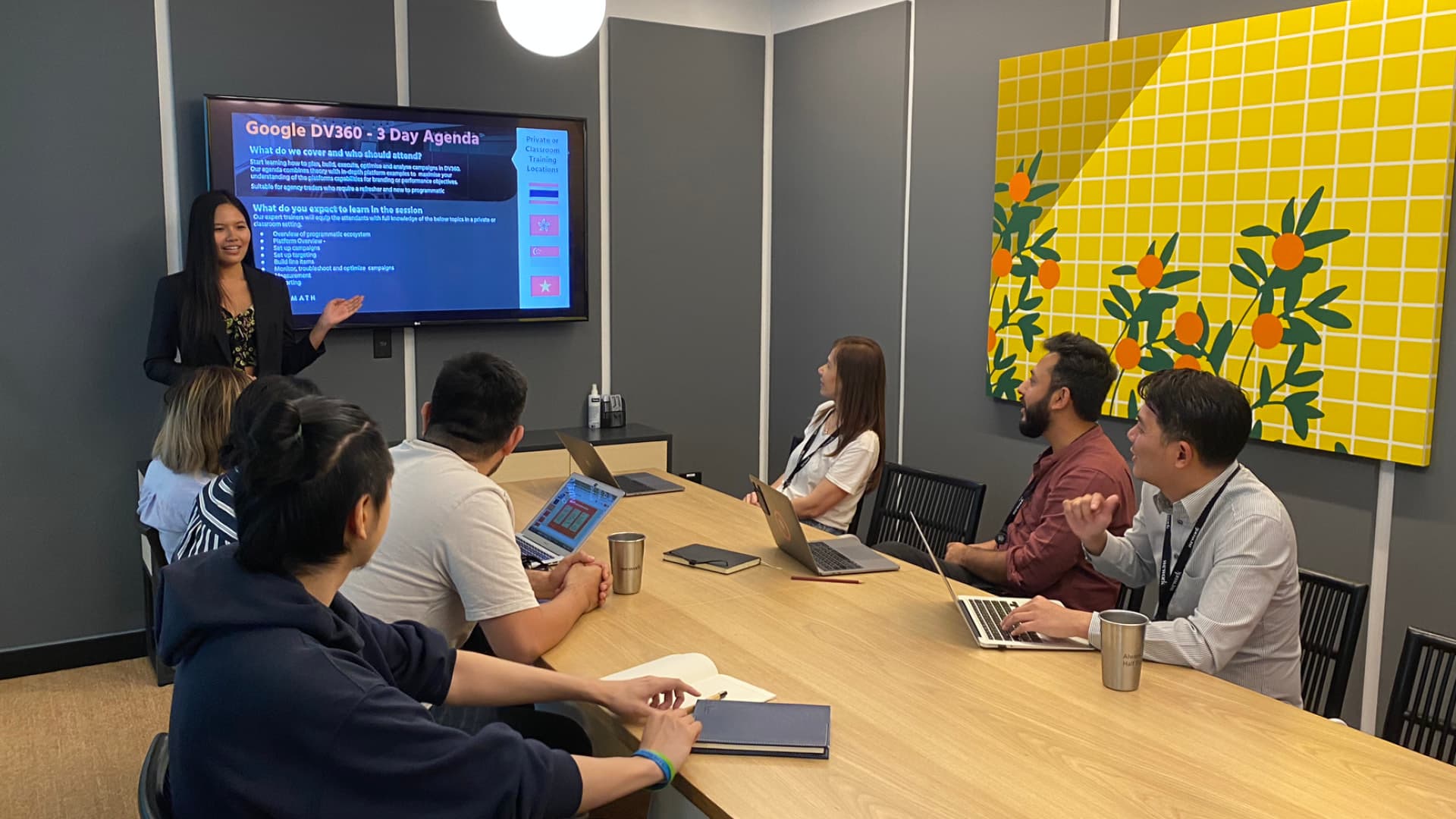 A trainer presenting the Google DV360 three-day agenda to a group around a meeting table