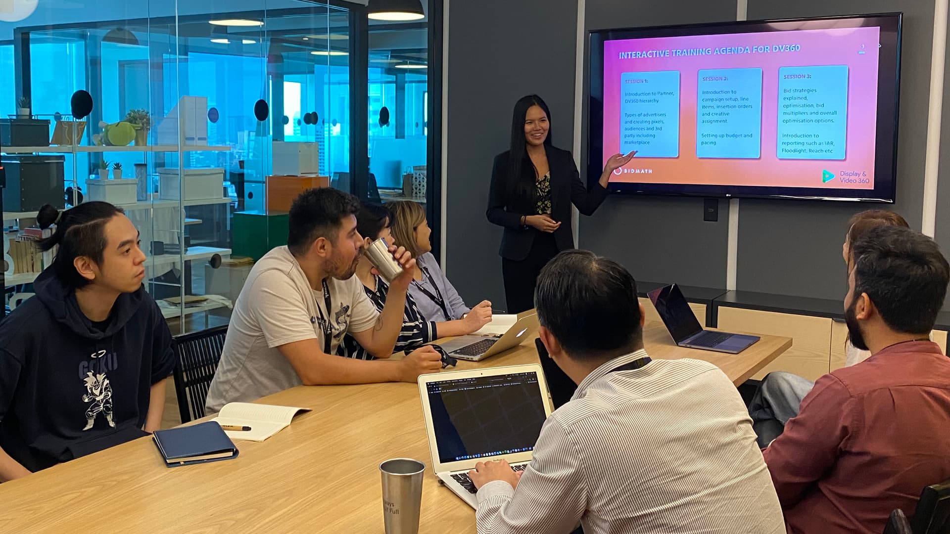 A trainer taking questions from attendees in a meeting room during a DV360 session